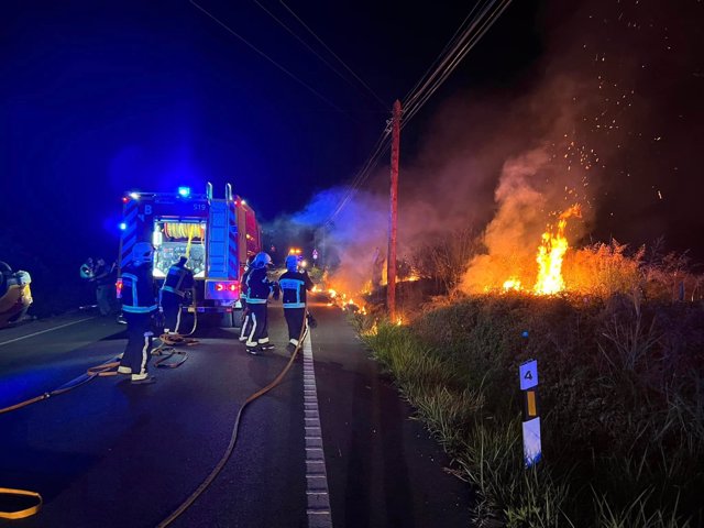 Bomberos intentan sofocar las llamas de la moto ardiendo.