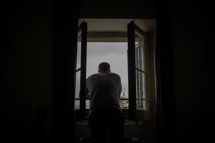 Archivo - Arxivo - Una persona treu el cap a la seva finestra durant el confinament a Barcelona