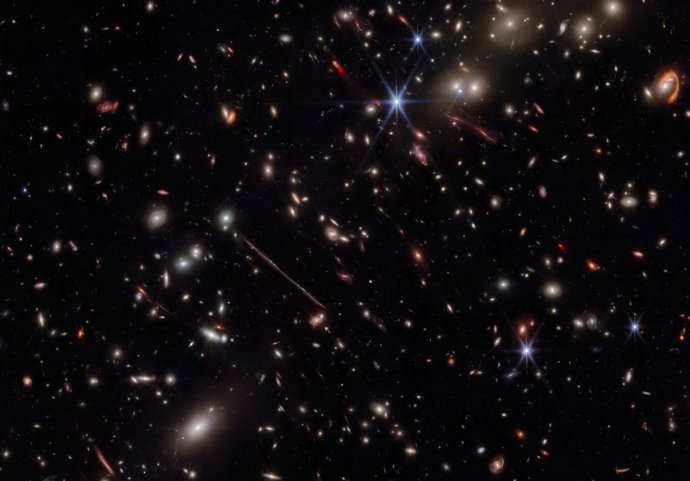 La imagen infrarroja de Webb del cúmulo de galaxias El Gordo revela cientos de galaxias, algunas nunca antes vistas con este nivel de detalle. El Gordo actúa como una lente gravitacional, distorsionando y magnificando la luz de galaxias de fondo distant