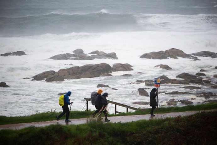 Archivo - Varios peregrinos realizan el Camino de Santiago, a pesar del temporal, en la zona de Santa Maria de Oia hasta Cabo Silleiro, a 20 de octubre de 2022, en Pontevedra, Galicia, (España). La borrasca Armand es la primera de gran impacto de la tem