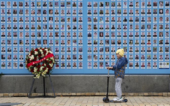 Archivo - Imagen de archivo de un niño frente a un memorial en la catedral de San Miguel en Kiev, Ucrania