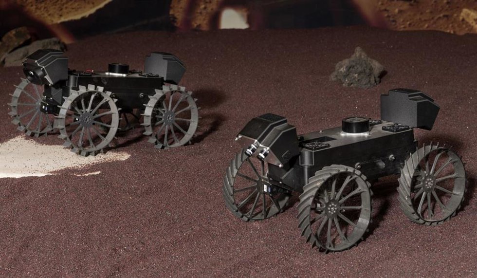 Un par de prototipos de plástico de los rovers CADRE demuestran la conducción en formación durante una prueba en el JPL el año pasado.