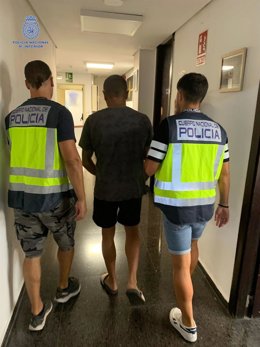 Dos agentes de la Policía Nacional escoltan al presunto autor del delito de lesiones.