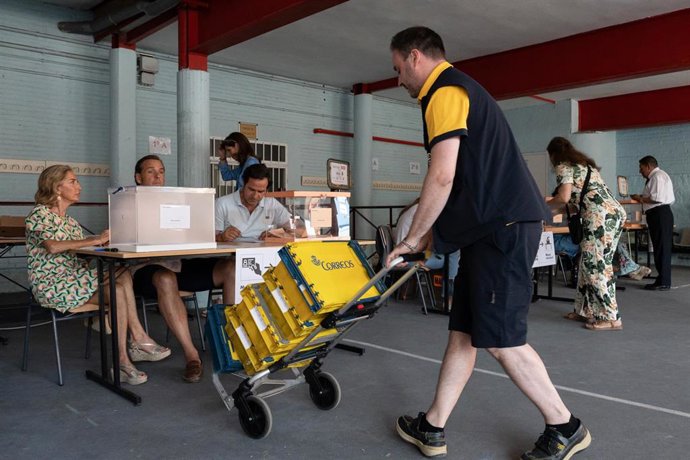 Un cartero llega al colegio electoral con el voto por correo correspondiente durante las elecciones generales, en el Colegio Ramiro de Maeztu