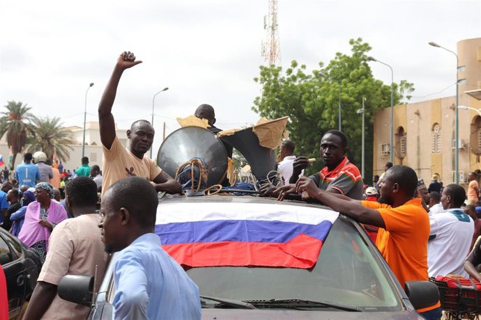 Nigerinos con una bandera de Rusia en Niamey durante una manifestación en apoyo al golpe de Estado