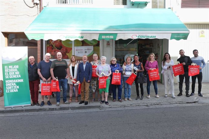 Representantes del Ayuntamiento de Larraga, de la Mancomunidad de Valdizarbe y vecinos de la localidad en la jornada de sensibilización realizada en uno de los comercios de proximidad del municipio