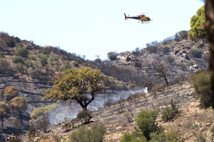 Un helicóptero trabaja en las labores de exinción de un incendio forestal en Colera