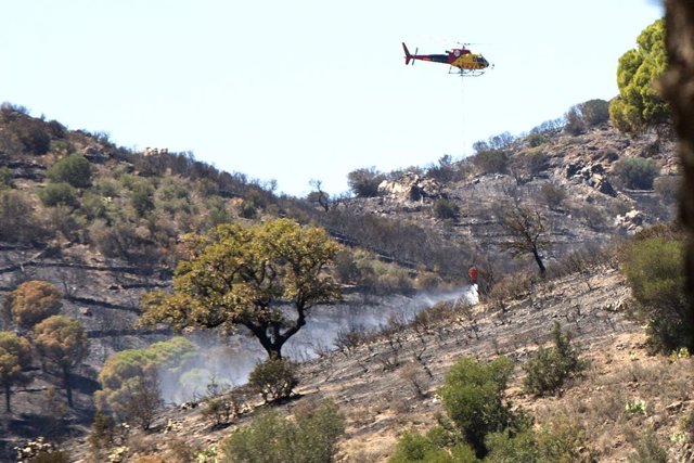 Un helicòpter treballa en les tasques d'extinció d'un incendi forestal a Colera