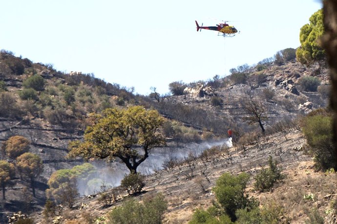 Un helicpter treballa en les tasques d'extinció d'un incendi forestal a Colera