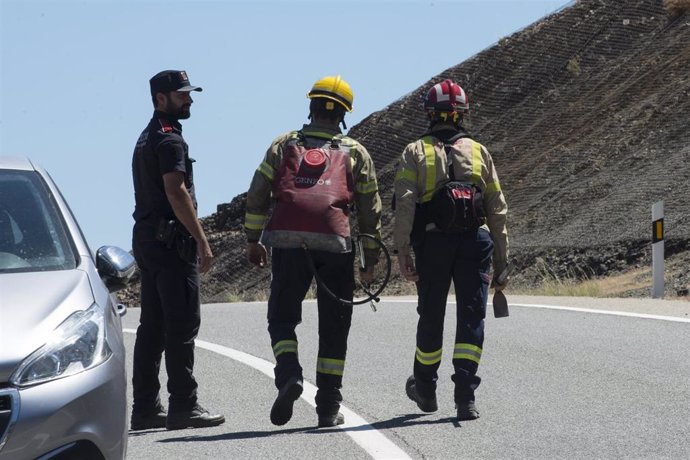 Bomberos y policía trabajan en las labores de extinción del incendio forestal de Colera