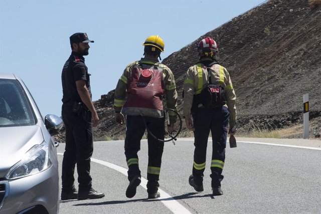 Bombers i policia treballen en les tasques d'extinció de l'incendi forestal de Colera