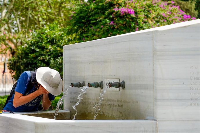 Una persona se refresca en una fuente pública de Sevilla en una imagen de archivo. 