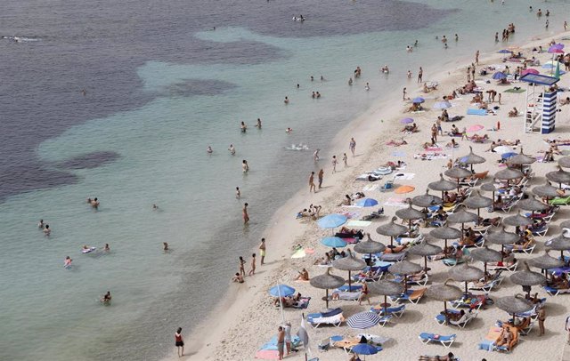 10 August 2021, Spain, Calvia: People sunbathe on the beach of Puerto Portals. Photo: Clara Margais/dpa