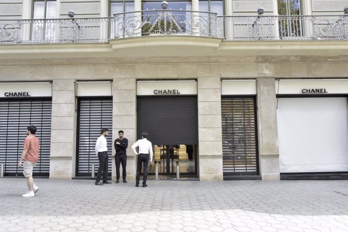 Diverses persones enfront de l'aparador de la botiga de Chanel que ha sofert aquesta matinada un intent de robatori, a 7 d'agost de 2023, a Barcelona, Catalunya (Espanya). 