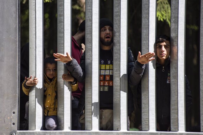 Archivo - May 28, 2023, Bialowieza, Podlaskie, Poland: Migrants with children seeking asylum are seen at the Belarusian side of the Polish border wall in Bialowieza. A group of 30 migrants and refugees from Iraq and Syria seeking asylum, including more 