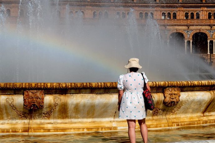 Turistas se refrescan en la fuente de la Plaza de España, en plena ola de calor a 07 de agosto del 2023 en Sevilla (Andalucía, España).