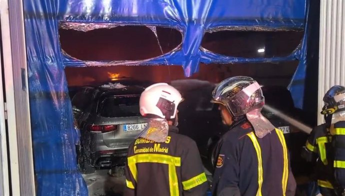 Bomberos de la Comunidad de Madrid extinguen un incendio en una nave de reparación de coches en Colmenar Viejo