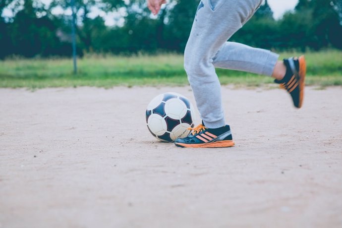 Archivo - Niño jugando a fútbol