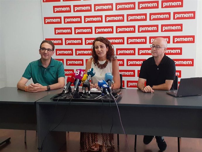 La presidenta de la Asociación de Troceadores de Algarroba, Juana Verger, con representantes de Pimem durante una rueda de prensa.