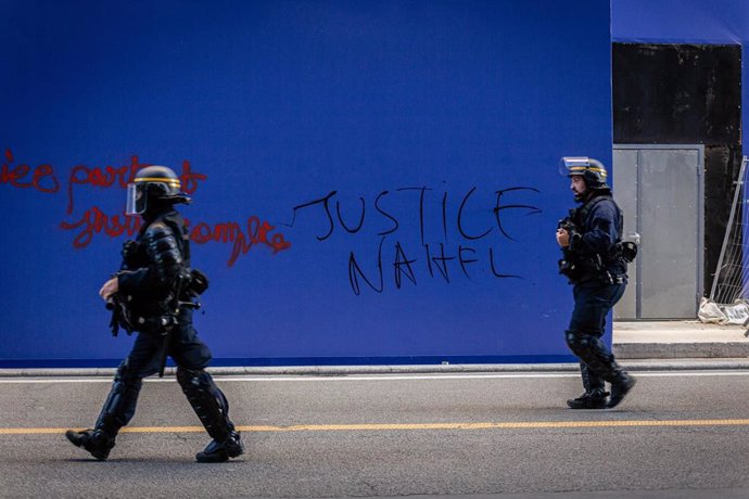 Archivo - Policías antidisturbios frente a una pintada pidiendo "Justicia para Nahel" en París, Francia