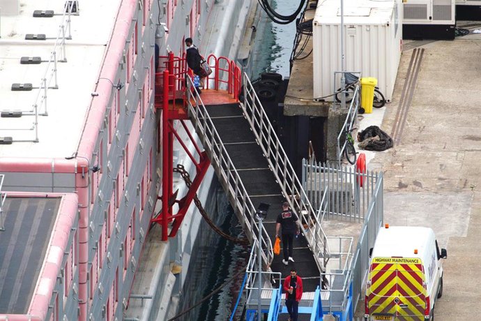 Migrantes embarcan en el buque 'Bibby Stockholm', atracado en el puerto de Portland