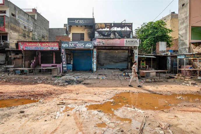 Un agente de Policía camina por una calle de Haryana tras enfrentamientos entre musulmanes e hindúes. 