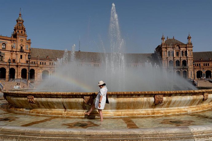 Turistas se refrescan en la fuente de la Plaza de España, en plena ola de calor a 07 de agosto del 2023 en Sevilla (Andalucía, España). La Agencia Estatal de Meteorología (Aemet) ha activado este martes el aviso naranja por altas temperaturas, desde las