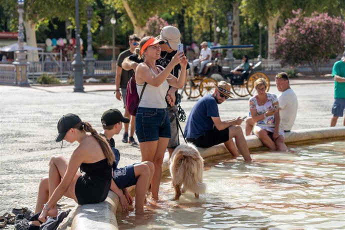 Turistas se refrescan en la fuente de la Plaza de España, en plena ola de calor a 07 de agosto del 2023 en Sevilla (Andalucía, España). 