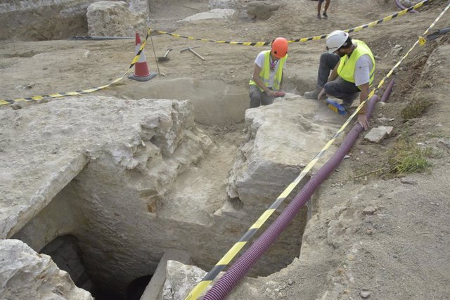 Arqueòlegs treballen al costat de les restes arqueològiques trobades a les obres de la Rambla de Barcelona