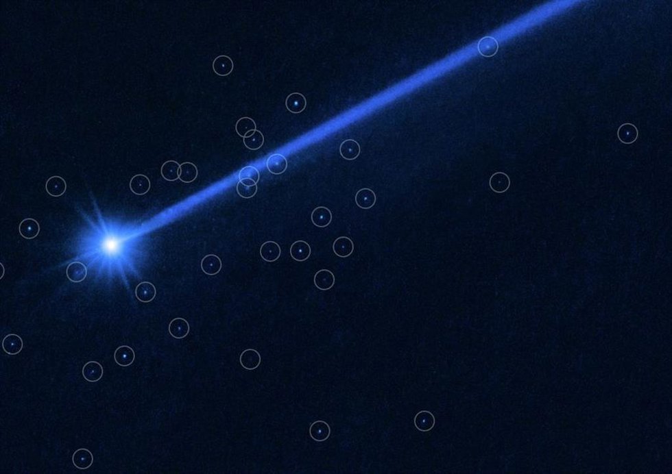 Una imagen del Telescopio Espacial Hubble del asteroide Dimorphos rodeado de rocas (pequeños puntos brillantes, dentro de un círculo) que fueron derribadas de la superficie del asteroide por la misión DART de la NASA.
