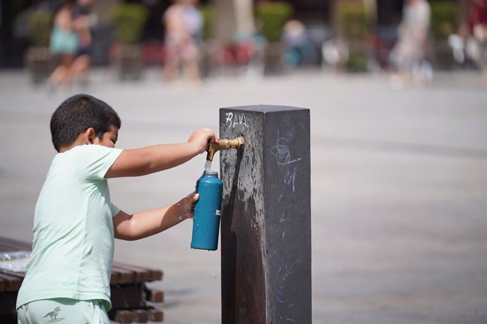 Un niño llena una botella de agua en una fuente, a 9 de agosto de 2023, en Vitoria Gasteiz, Álava, País Vasco (España).