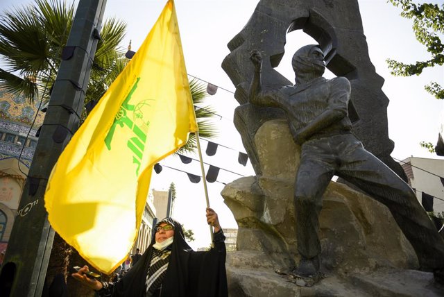 Archivo - August 9, 2022, Tehran, Tehran, Iran: A young woman holds Lebanon's Hezbollah flag during a Protest gathering against Israel in downtown Tehran.