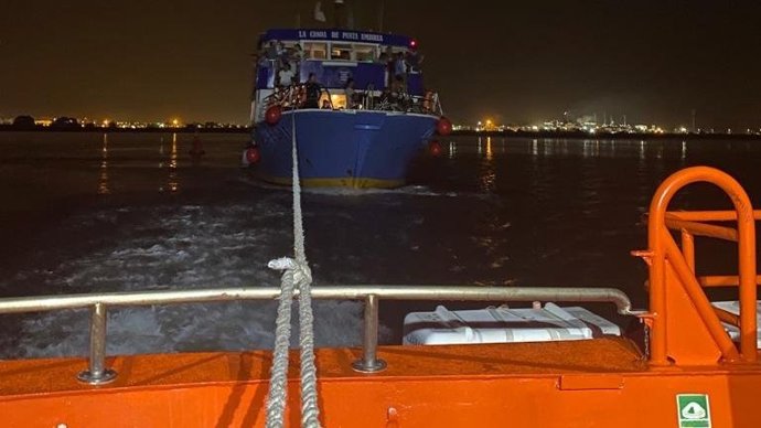 La canoa de Punta Umbría remolcada en la ría tras una avería mientras realizaba un viaje desde Huelva capital.