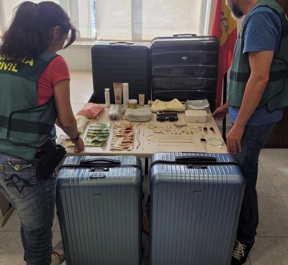Agentes de la Guardia Civil junto a las maletas recuperadas.