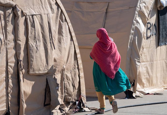 Archivo - 09 October 2021, Rhineland-Palatinate, Ramstein: An Afghan woman walks among refugee tents at the US airbase in Ramstein. The US is resuming flights from Ramstein for people who are expected to be flown out of the base to USA over the next few