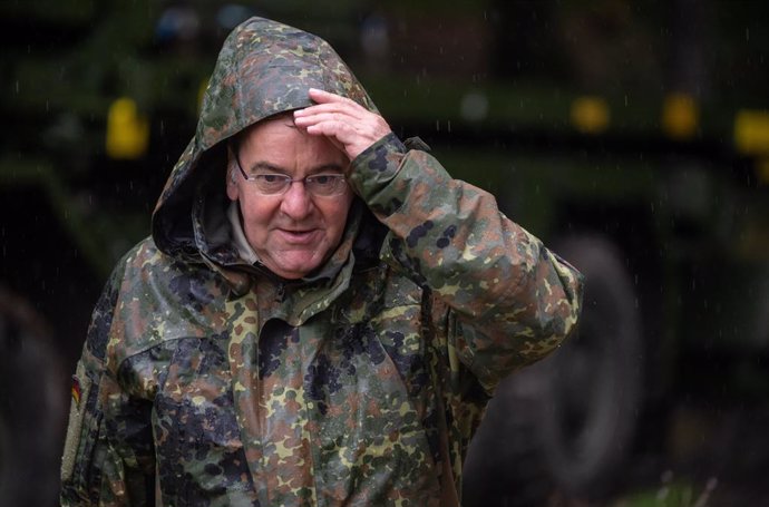 03 August 2023, Bavaria, Bischofswiesen: Defense Minister Boris Pistorius puts on his hood in the pouring rain during his visit to the Mountain Infantry Brigade 23 in Bad Reichenhall and Bischofswiesen. Photo: Peter Kneffel/dpa