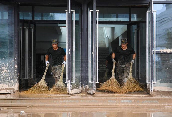 Agentes de la Policía limpian los efectos de las lluvias torrenciales por el tifón 'Doksuri' en una escuela en la región de Hebei