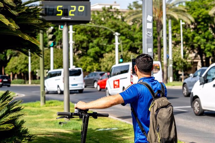 Turistas se hacen una fotos detrás de un termómetro que marca 52 grados, en plena hora de calor, a 07 de agosto del 2023 en Sevilla (Andalucía, España). La Agencia Estatal de Meteorología (Aemet) ha activado este martes el aviso naranja por altas temper