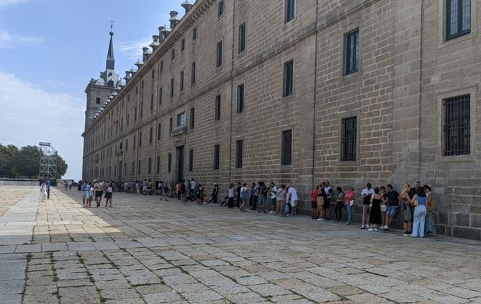 Visitantes a la sombra de la fachada del Real Monasterio de San Lorenzo del Escorial.