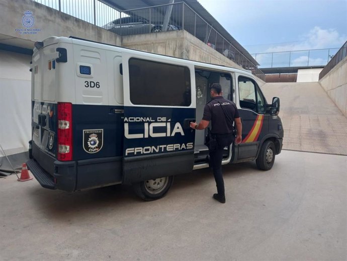 Un agente de la Policía Nacional de Ibiza junto a un furgón.