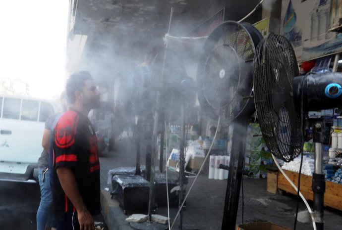Archivo - (210629) -- BAGHDAD, June 29, 2021 (Xinhua) -- People stand in front of fans to cool off at a market in central Baghdad, Iraq, on June 29, 2021. Scorching weather started here in June and temperatures rose to about 50 degrees Celsius.