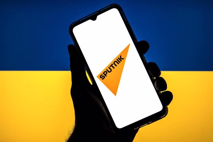 Archivo - Logo de Sputnik frente a la bandera de Ucrania (Archivo)