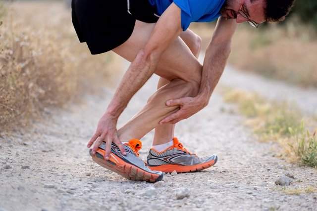 Archivo - Close up of runner touching painful twisted or broken ankle shin or calf athlete runner training accident sport running ankle sprain concept