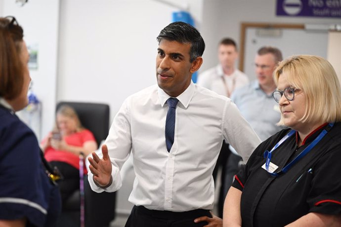 15 August 2023, United Kingdom, Milton Keynes: UKPrime Minister Rishi Sunak speaks to staff and patients in the SDEC, same day emergency care unit during a visit to Milton Keynes University Hospital, following the announcement that the Government has r