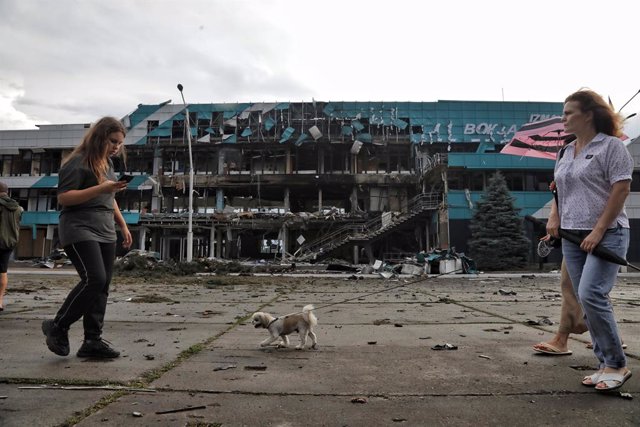 02 August 2023, Ukraine, Izmail: A woman walks a dog outside the building of the Marine Terminal damaged in the Russian drone attack on the port infrastructure of Izmail situated on the Danube River Wednesday night. Photo: -/Ukrinform/dpa