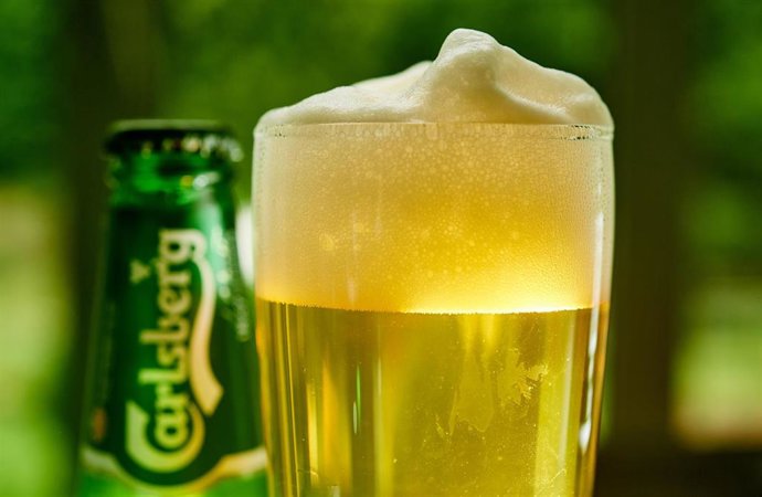 Archivo - FILED - 12 June 2018, North Rhine-Westphalia, Herdecke: A general view of a glass of beer and a can of Carlsberg beer on a table. Danish brewer Carlsberg on Thursday said it was expecting to deliver an organic operating profit decline of 10-15