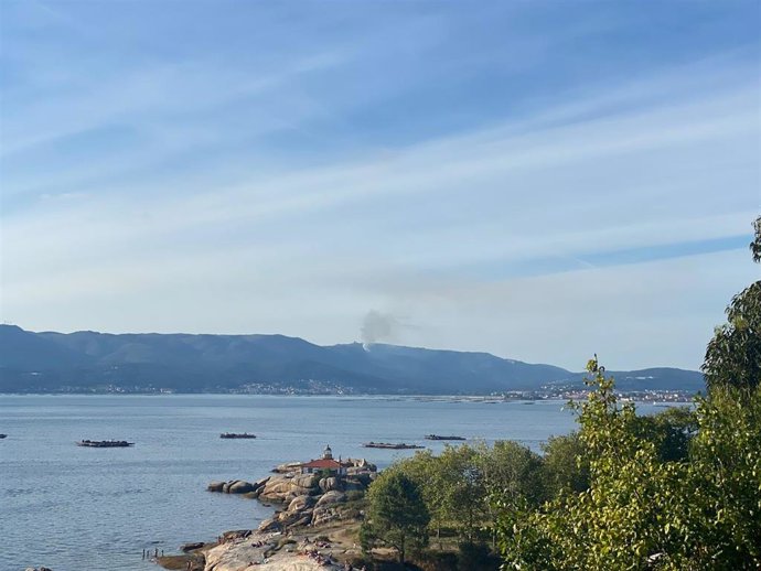 Pequeño incendio en la parroquia de Cures, en Boiro (A Coruña), visto desde A Illa de Arousa (Pontevedra).