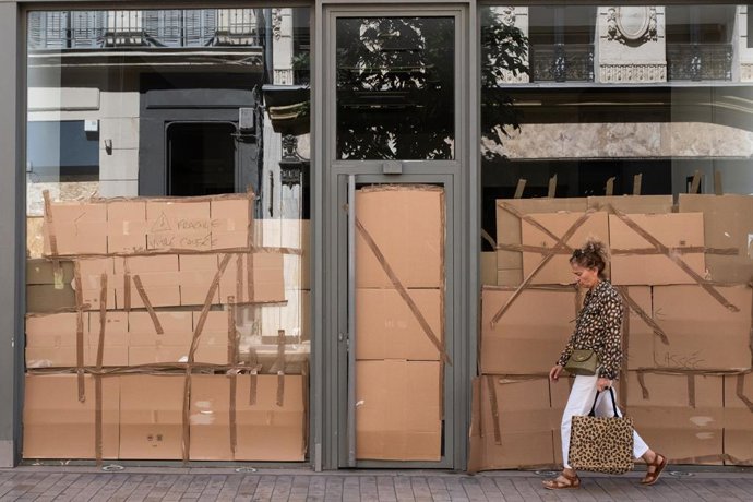 Archivo - July 3, 2023, Marseille, France: A woman walks past a destroyed shop window protected by cardboard boxes in Marseilles city centre. In support of the mayor who was attacked at his home in L'Hay-les-Roses during the urban riots on Saturday 01 J