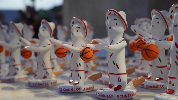 Figuras de 'Siurells' con una pelota de baloncesto en la mano para conmemorar los 30 años del partido más largo de la historia del baloncesto, jugado por el Club Bsquet Es Pla