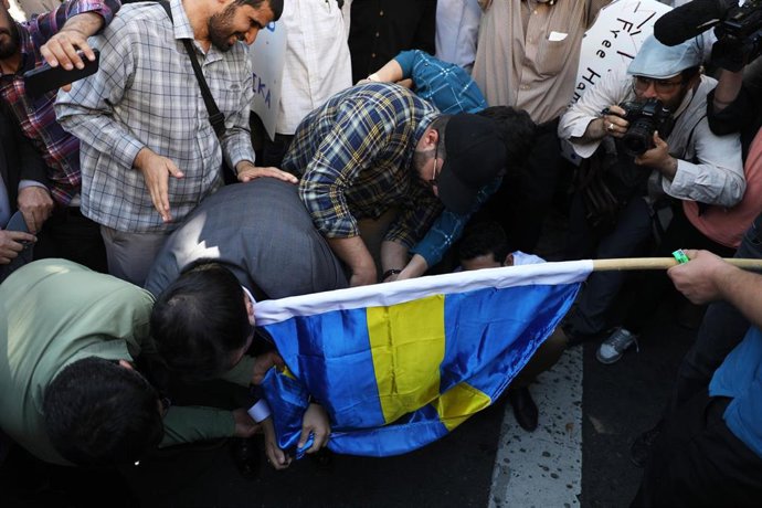 Archivo - Un grupo de manifestantes quema una bandera sueca en Teherán